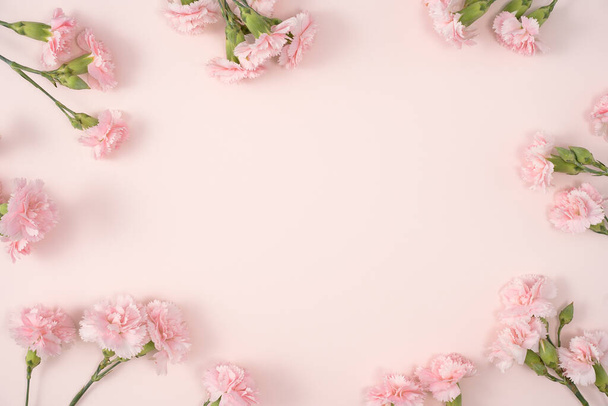 Design koncepció anyák napja ünnep üdvözlő design szegfű csokor pasztell rózsaszín asztal háttér - Fotó, kép
