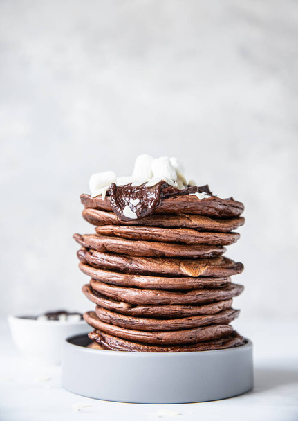 Chocolate pancakes with melted chocolate, ground almond and marshmallow, light background. Selective focus. - Φωτογραφία, εικόνα
