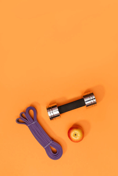 masszázs görgő súlyzó sport hámot alma és törölköző narancs alapon - Fotó, kép