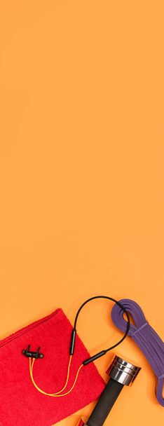 マッサージローラーダンベルスポーツハーネスアップルとタオルオレンジの背景パノラマ - 写真・画像