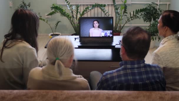 Videochats von zu Hause aus. Fünf Personen kommunizieren von zu Hause aus per Videoverbindung. Mitglieder einer Familie sitzen auf der Couch. Sie kommunizieren mit Verwandten oder Bekannten über einen Laptop. - Filmmaterial, Video