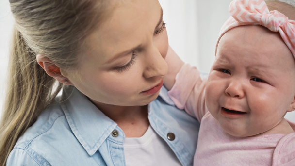 Mutter hält weinendes Baby im Arm - Foto, Bild