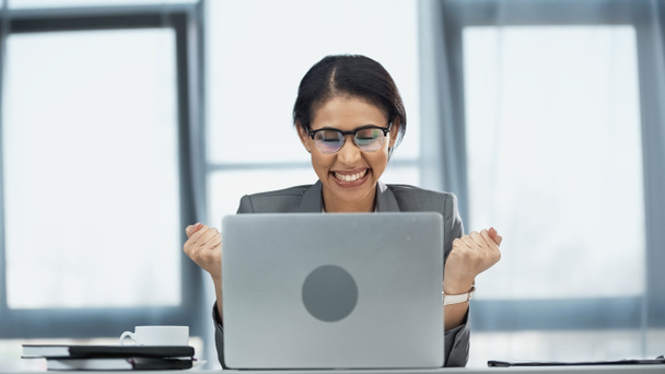 podekscytowany afrykański amerykański bizneswoman w okulary patrząc na laptopa - Zdjęcie, obraz