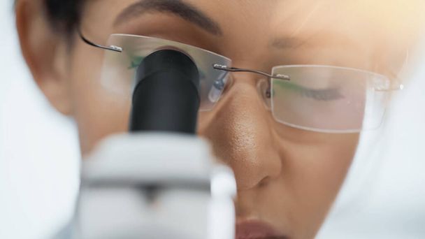 gros plan d'un scientifique afro-américain à lunettes regardant au microscope en laboratoire  - Photo, image