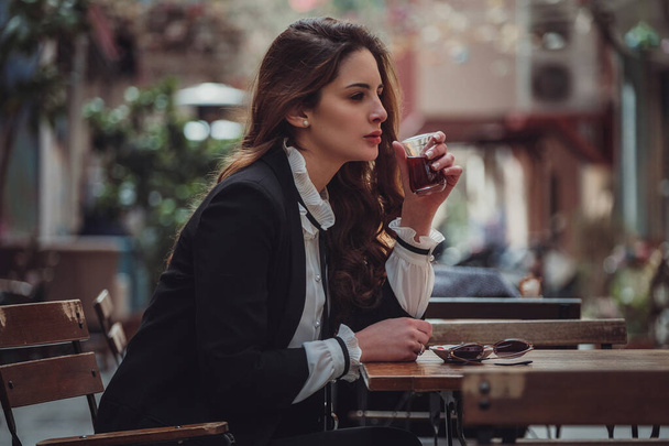 Une femme latine traverse la vieille ville du Moyen-Orient. Femme voyageuse à Istanbul et boit du thé à la dinde dans un café, quartier de Beyoglu, Istanbul, Turquie. - Photo, image