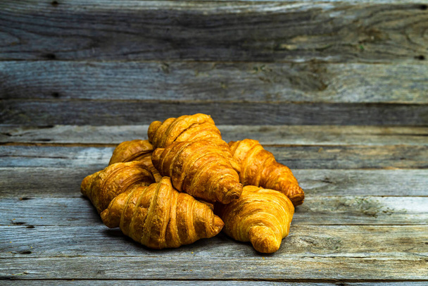 Heerlijke, verse croissants geïsoleerd op houten plank. Frans ontbijtconcept. - Foto, afbeelding