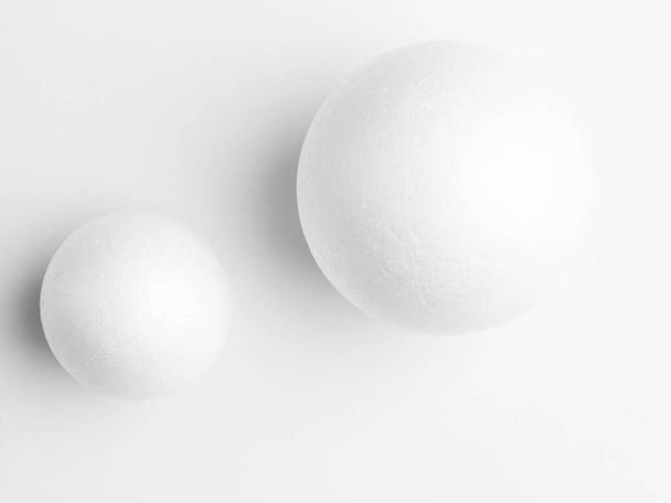 Άσπρες μπάλες φωτογραφιών, σε λευκό φόντο χαρτιού. Μελέτη μαλακού φωτός - Φωτογραφία, εικόνα