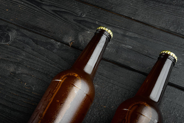 Bouteilles de bière en verre, sur fond en bois noir, avec espace de copie pour le texte - Photo, image