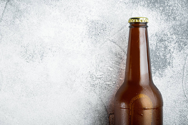 Gri taş zemin üzerinde cam bira şişeleri, üst görünüm düz, metin için kopyalama alanı ile - Fotoğraf, Görsel