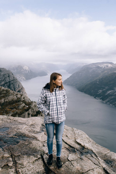 Una chica bonita se para en la cima del Monte Preikestolen (Pulpit Rock) en Noruega - Foto, Imagen