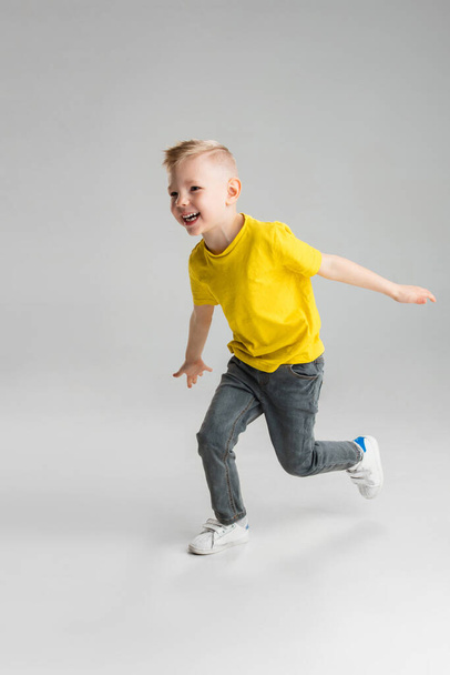 Happy boy isolated on white studio background. Looks happy, cheerful, sincere. Copyspace. Childhood, education, emotions concept - Foto, Bild