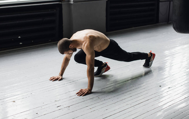 Joyful athletic man doing exercise with push-up while working out - Foto, Bild