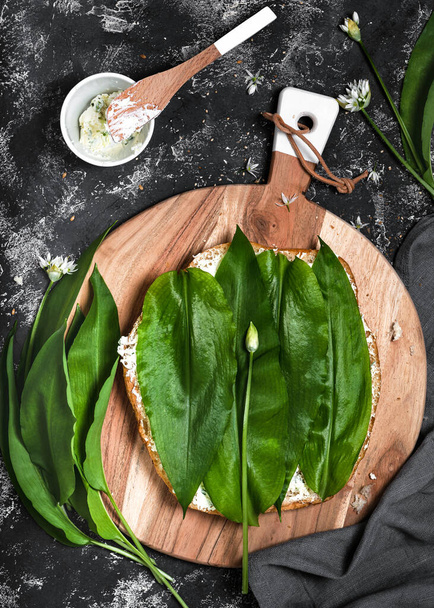 Making of sandwiches with homemade flatbread, creamy dip and fresh wild garlic leaves. Cooking healthy vegetarian food. - Valokuva, kuva