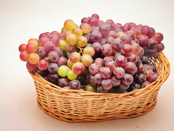 Uvas rojas en la cesta de la fruta, Fondo blanco - Foto, imagen