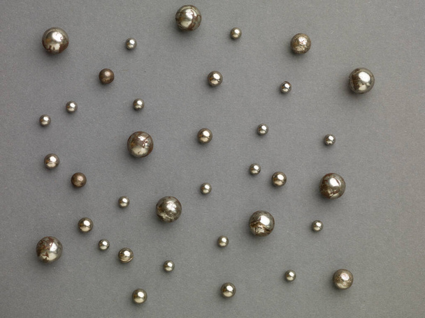 geroest geoliede oude kogellagers bollen geplaatst op een grijze achtergrond - Foto, afbeelding
