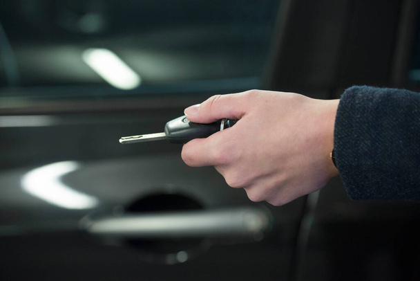 osoba držící klíček od auta k zamknutí nebo otevření vozu - Fotografie, Obrázek