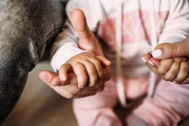 Χαριτωμένη φωτογραφία των χεριών ενός μικρού κοριτσιού και των γονιών της. Κοντινό πλάνο. Οικογένεια, υποστήριξη - Φωτογραφία, εικόνα