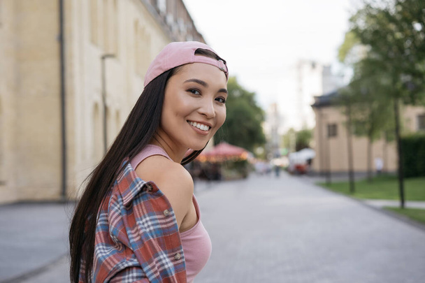 Portrait of beautiful smiling asian woman wearing stylish casual clothing looking at camera. Summertime, positive lifestyle concept, copy space - Photo, Image