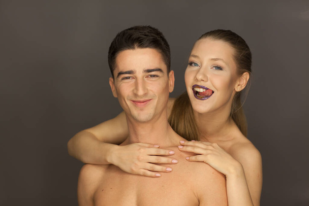 beautiful couple in studio portrait front view pose for the camera, the woman behind smile - Photo, Image