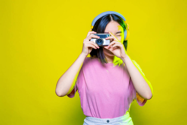 молодая азиатская женщина делает фотографии с ретро фотокамеры изолированы - Фото, изображение