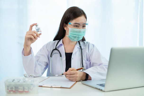 Asian female doctor reporting a diagnostic result of Coronavirus or COVID-19 vaccine usage in patient, 2019-nCoV COVID19 cases statistic. Woman doctor - researcher making a video conference. - Foto, Imagem