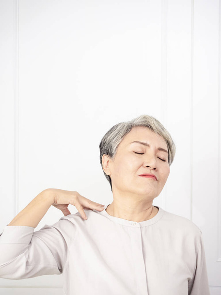 首に触れる病気の高齢者の高齢者の女性は肩や首の痛みを持っています. - 写真・画像