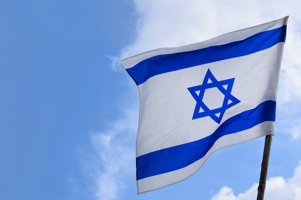 İsrail Devleti 'nin mavi ve beyaz bayrağı. David' in yıldızı rüzgarda dalgalanırken. Parlak gökyüzü. - Fotoğraf, Görsel