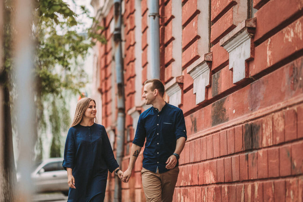 Happy couple in love walks the city streets together. A lovely couple on the old narrow streets of the city. Lifestyle of smiling people. Family relations concept - 写真・画像