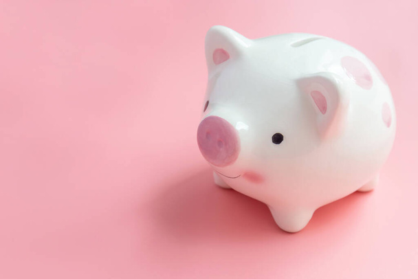 Ceramic piggy bank with copy space on pink background for saving concepts - Photo, Image