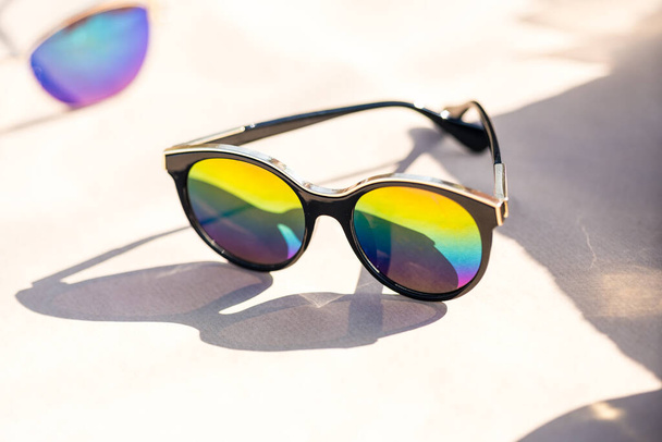 Fashion kattenoog zonnebril model voor dames met grote ronde gekleurde lenzen en zwarte frame shoot buiten in een zonnige dag close-up. Selectieve focus  - Foto, afbeelding