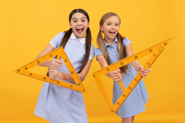 Learn what angles are. Happy teen girls hold triangular rulers. Geometry lesson. Preparing lesson. Homework. Back to school. Knowledge day. September 1. - Photo, Image