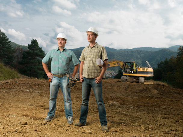 two young caucasian engineers standing on construction site outdoors - Photo, Image