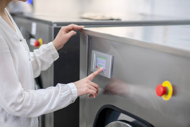 Womans hand touching panel of washing machine - Photo, Image