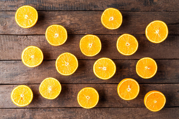 Juicy orange halves on wooden table. Top view - Foto, afbeelding