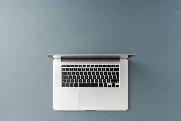 Overhead-Aufnahme eines Laptops auf grauem Hintergrund mit Copyspace. Büro-Desktop. Flache Lage - Foto, Bild