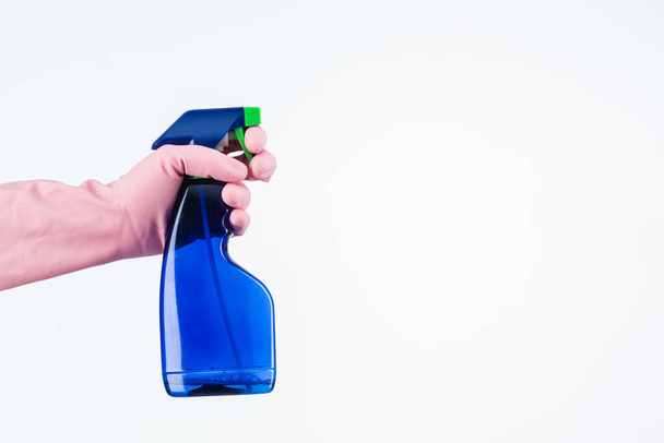 human hand with protective glove holding cleaning spray bottle. isolated on white - Photo, Image