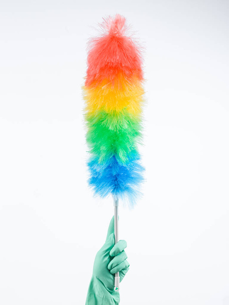 human hand wearing rubber glove holding up feather duster - Photo, Image