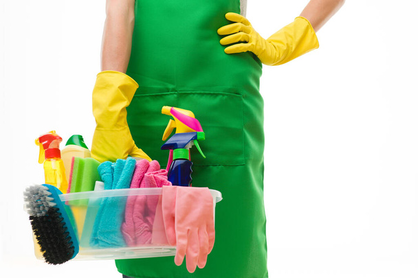 close-up of caucasian cleaning lady holding basin with cleaning supplies, against white background - Photo, Image