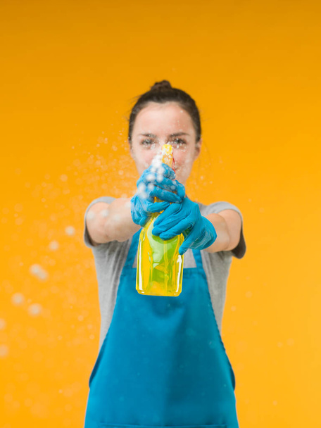 woman spraying cleaning detergent on surface in front of her - Foto, Imagen