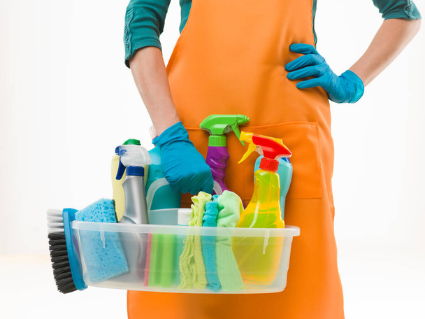 close-up of caucasian woman holdinh basin with cleaning supplies, on white background - Valokuva, kuva