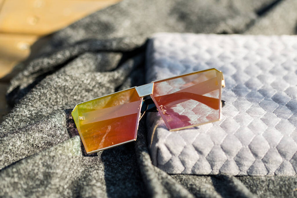 Zróżnicowany model okularów przeciwsłonecznych z dużymi płaskimi soczewkami kręci się na zewnątrz w słoneczny dzień zbliżenia. Skupienie selektywne - Zdjęcie, obraz