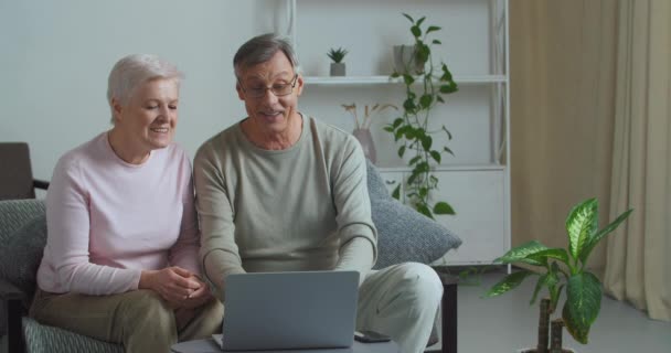 Velho marido e esposa avó e avô falam em videoconferência on-line usando tecnologias modernas se comunicar com as crianças remotamente convidar convidados fazer gesto de boas-vindas com as mãos - Filmagem, Vídeo