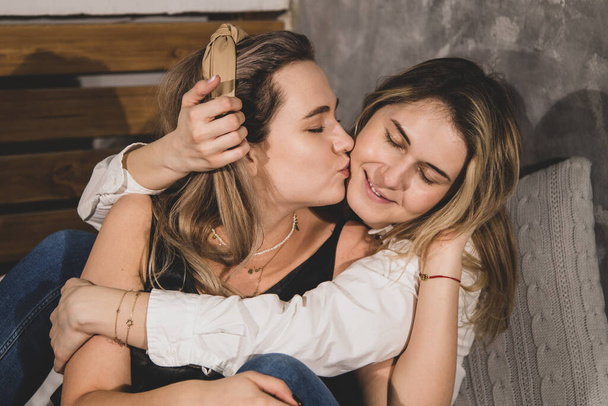 Czuły związek w rodzinie lesbijek, jedna piękna kobieta całuje swojego partnera. Portret z bliska - Zdjęcie, obraz