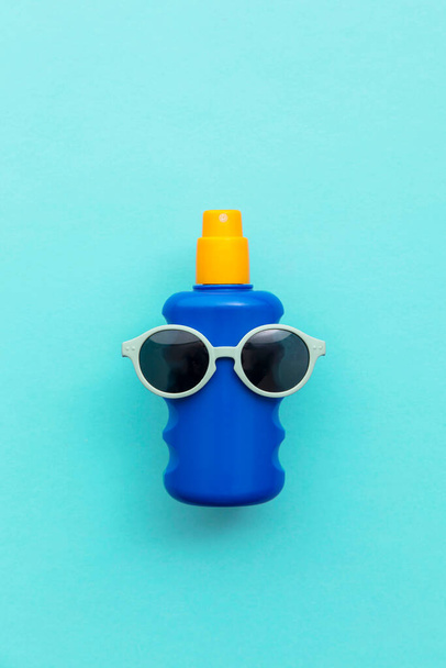 Summer holiday vacation background. Bottle of sun cream with sunglasses - Fotó, kép