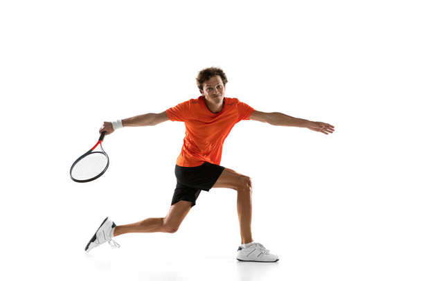 Joven hombre caucásico, jugador de tenis entrenando aislado sobre fondo blanco. - Foto, Imagen