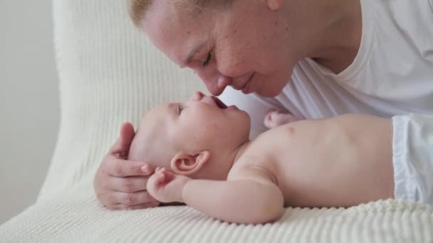4k. gelukkige moeders gezicht kussen spelen met kleine baby. Gezicht tegen gezicht - Video