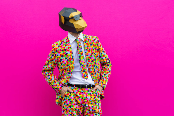 Happy man with funny low poly mask on colored background - Creative conceptual idea for advertising,adult with low-poly origami paper mask doing funny poses - Foto, immagini