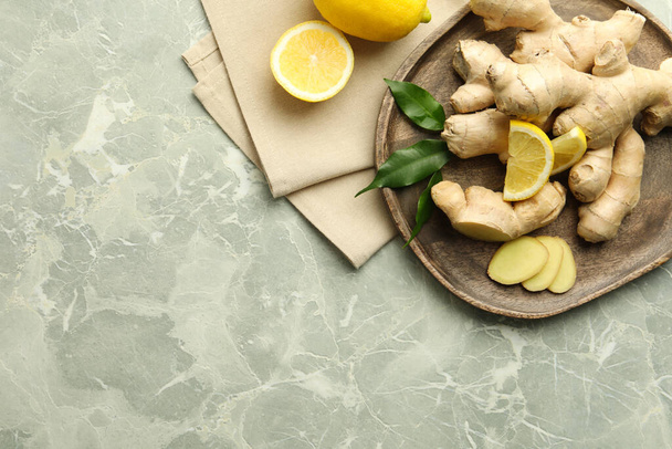 Fresh lemons and ginger on grey marble table, flat lay. Space for text - Valokuva, kuva