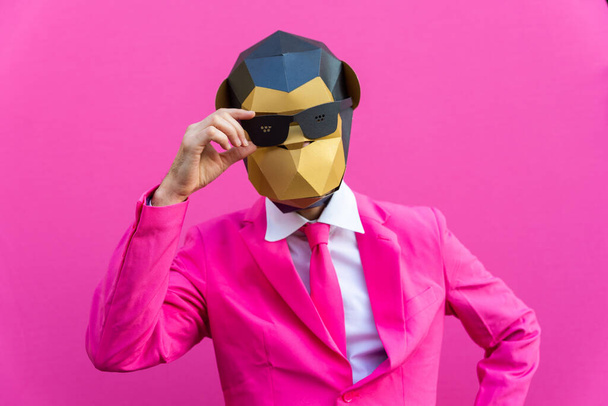 Happy man with funny low poly mask on colored background - Creative conceptual idea for advertising,adult with low-poly origami paper mask doing funny poses - 写真・画像