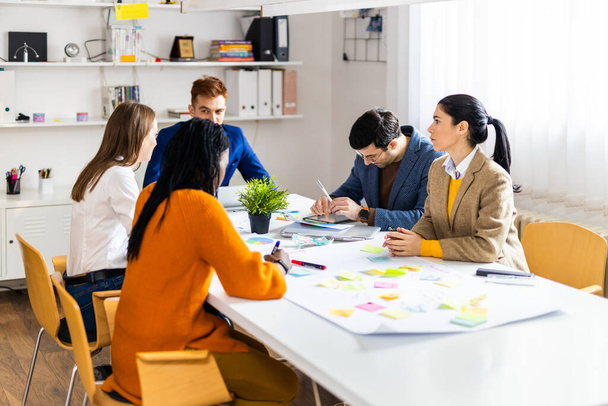 Project managers and employees brainstorming on ideas - Multi-ethnic group of workers having business meeting in a start-up office - Foto, imagen